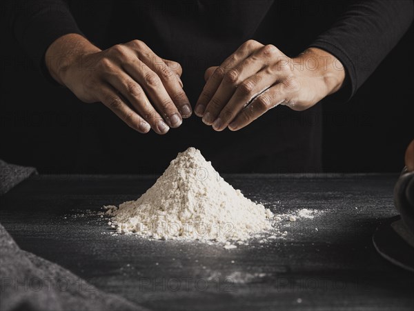 Front view baker hands mixing flour