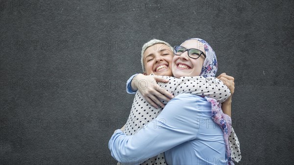 Friends sharing hug with black background