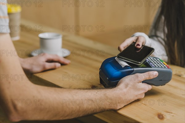 Barista accepting payment with smartphone