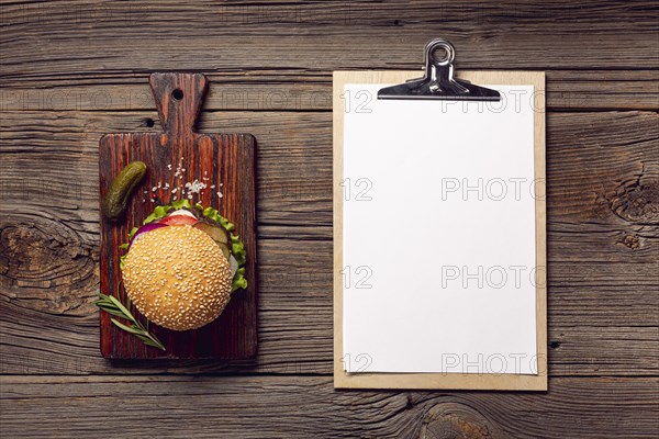 Flat lay burger with mock up clipboard