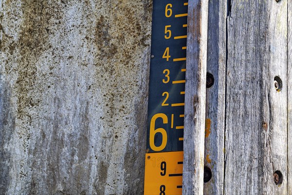 Water level gauge in the harbour basin at high tide and flood