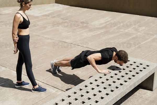 High angle woman man doing push ups outdoors