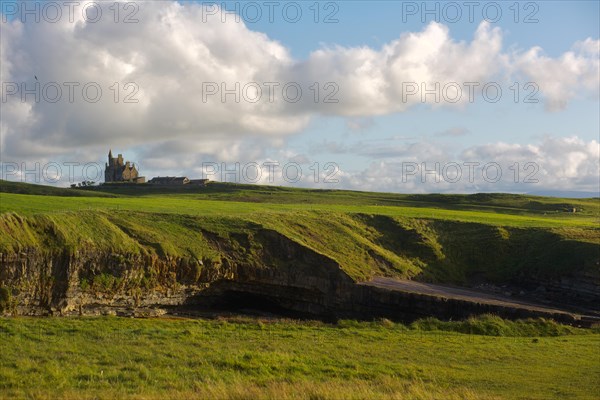 Beautiful sunlight on green coastal grass along the Wild Atlantic Way with Classiebawn Castle in the background. County Sligo