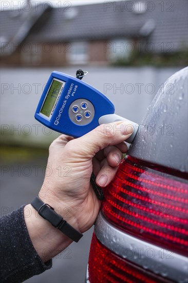 Testing the thickness of paint on a car