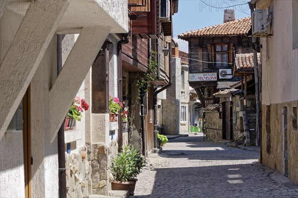 Half-timbered houses with wooden tops and roof overhangs typical of the locality on the cobbled street in the old town. Sozopol