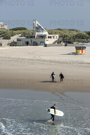 Surfers leaving the water and walking to the O'Neill Beach club in Blankenberge
