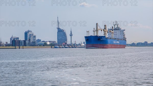 Cargo ship on the Weser in front of the city skyline