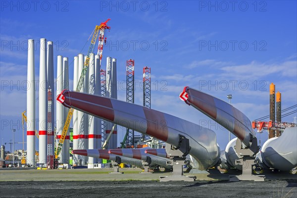 Wind turbine parts like huge rotor blades and steel tower sections for assembling wind turbines at REBO heavy load terminal in Ostend port
