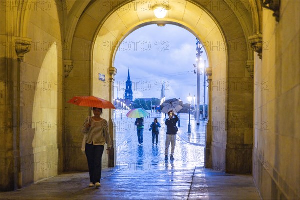 Tourists pass the Georgentor in the rain.