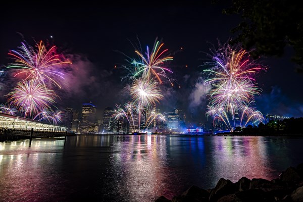 Independence day celebration in New York City with Macy's Fireworks in Lower Manhattan on East River and Brooklyn Bridge