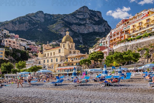 Beach with beach chairs and the church of Santa Maria Assunta