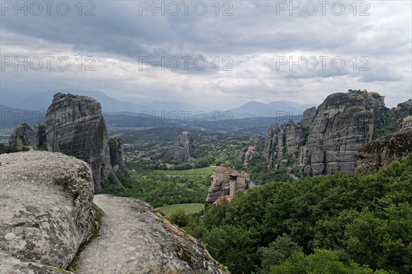 The monastery of Roussanou and behind it the monastery of Agios Nikolaos Anapafsas on sandstone rocks above the Pinios valley. The Greek Orthodox Meteora monasteries are built on sandstone cliffs above the Pinios valley. They are a UNESCO World Heritage Site. Kalambaka