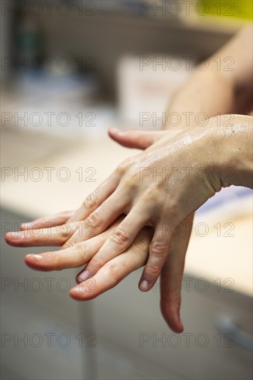 A doctor prepares for an operation and sterilises her hands with disinfectant