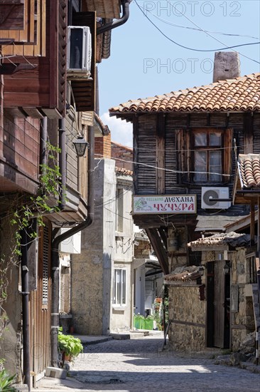 Half-timbered houses with wooden tops and roof overhangs typical of the locality on the cobbled street in the old town. Sozopol