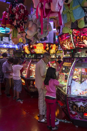 Father with girl playing with coin pusher