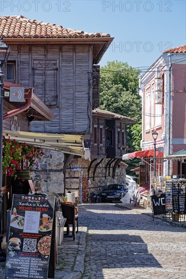 Half-timbered houses with wooden tops and roof overhangs typical of the locality on the cobbled street in the old town. Sozopol