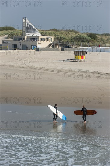 Surfers leaving the water and walking to the O'Neill Beach club in Blankenberge