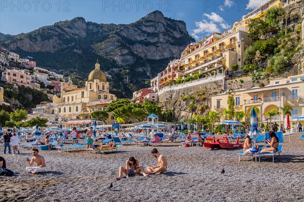 Beach with beach chairs and the church of Santa Maria Assunta