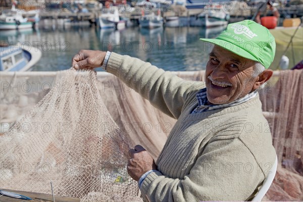 Fishermen mending nets in the Old Port of Antalya