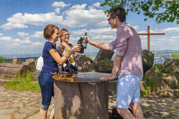 Three young people drinking their after-work beer on the Birkenkopf above Stuttgart