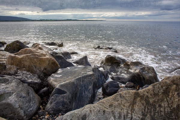 Sunshine glitters on rocks and the Atlantic Ocean during lovely weather in AuguSt Strandhill