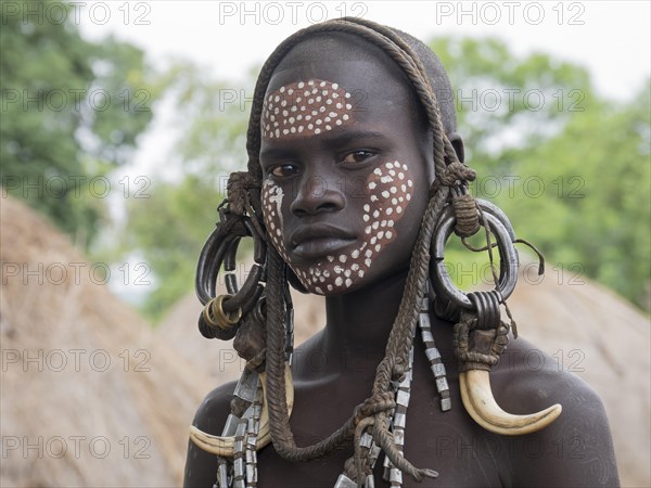 Girl of the Mursi tribe with headdress and face painting
