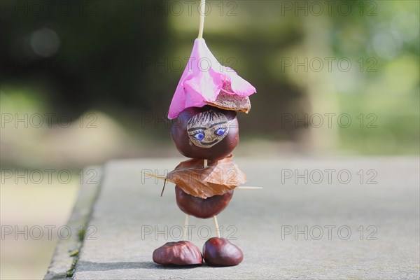 Funny chestnut figure with blossom on head