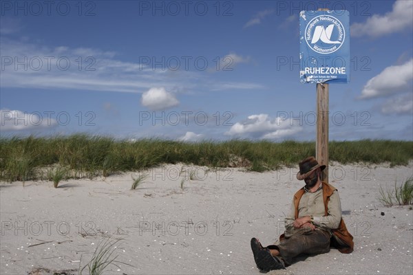 Bird warden resting at a National Park sign