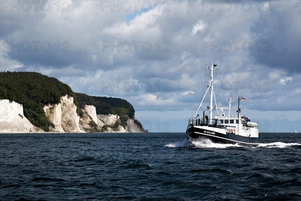 Cutter in front of chalk cliffs and chalk coast