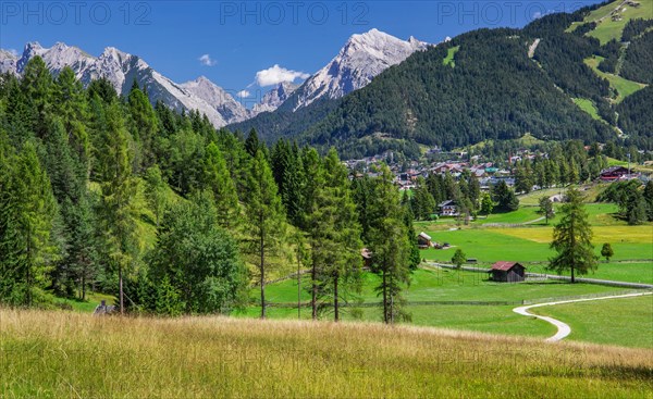 Landscape on the high plateau with a view of the village and the northern Karwendel mountain range