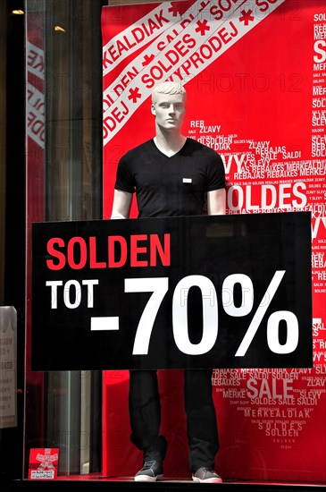 Discount notices showing deductions in shop window of clothes store during the summer sales in shopping street