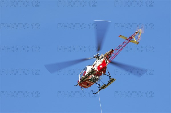 Swiss rescue helicopter in flight in the Alps