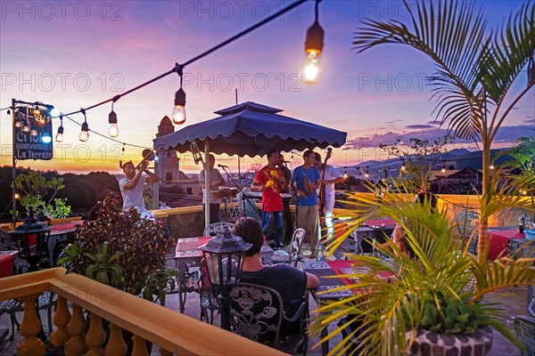 Cuban band at sunset with musicians playing salsa music at rooftop bar in the city Trinidad