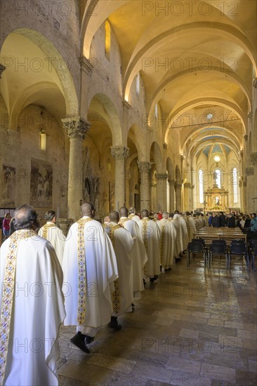 Priests in solemn vestments enter the Cathedral di San Cerbone for Mass on Holy Thursday