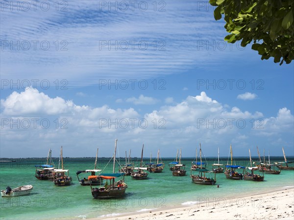 Boats on the white beach in the turquoise sea