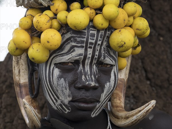 Woman of the Mursi tribe with headdress and face painting