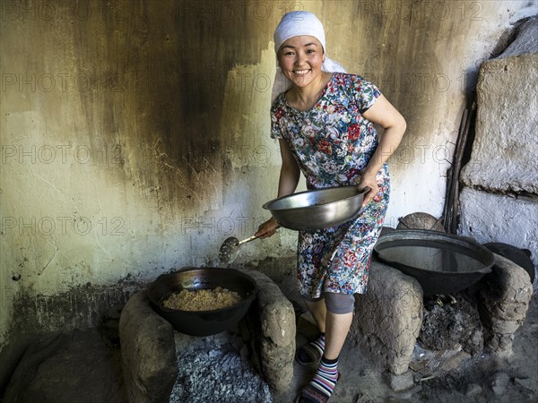 Young woman preparing rice dish Plov