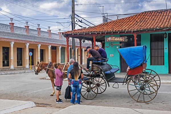 Tourists and horse-drawn carriage in front of restaurant El Cabildo in the city Ciego de Avila on the island Cuba
