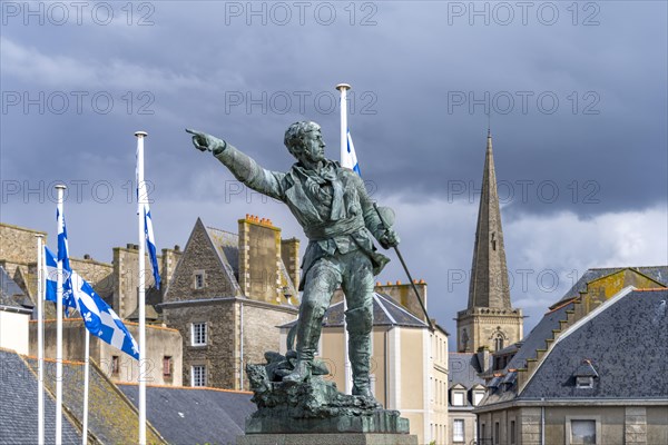 Statue of the privateer Robert Surcouf in front of the old town with the tower of St Vincent Cathedral