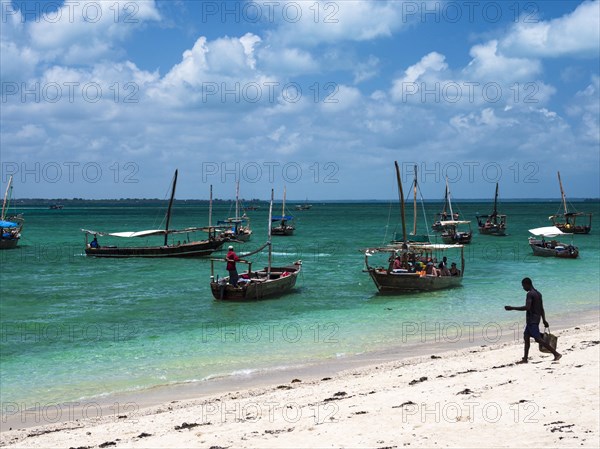 Boats on the white beach in the turquoise sea