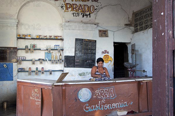 Shopkeeper behind counter of Cuban state shop in Cienfuegos