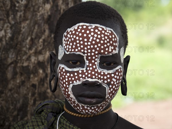 Girl from the Mursi tribe with face painting