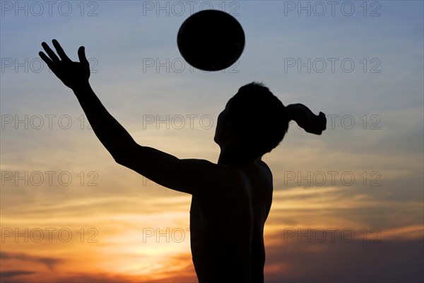 Young man playing volleyball on the beach