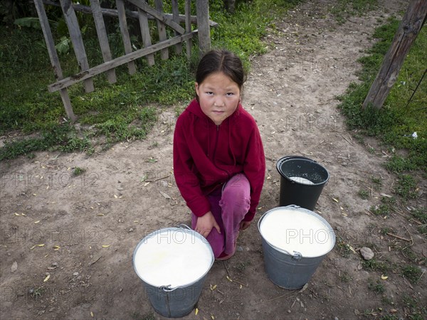 Little girl with freshly milked milk in buckets