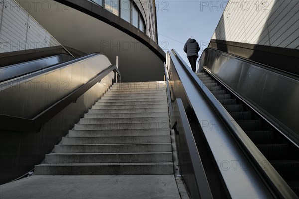 A man reaches the top of an escalator in downtown Munich. Munich