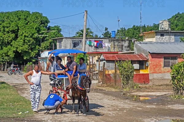 Cuban repairing horse-drawn taxi carriage in rural village in the Sierra Maestra