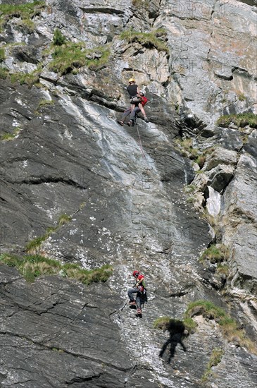 Swiss rescue helicopter winching rescuer and climber