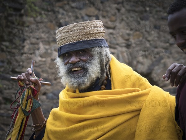 Old priest with yellow cloak