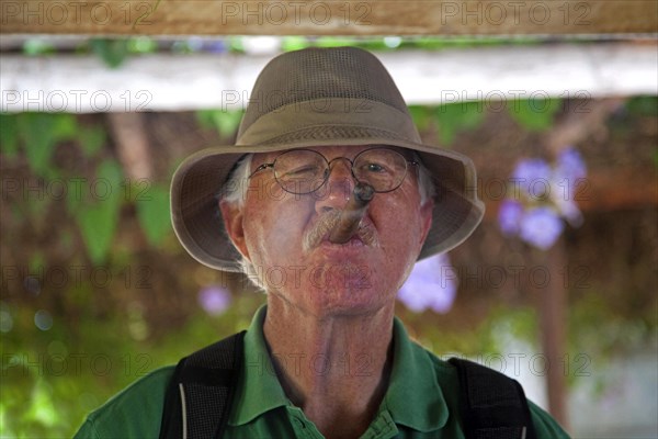 Old man with hat smoking a hand rolled Cuban cigar in Vinales