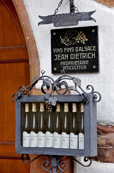 Viticulturist's signboard and wine bottles at Kaysersberg